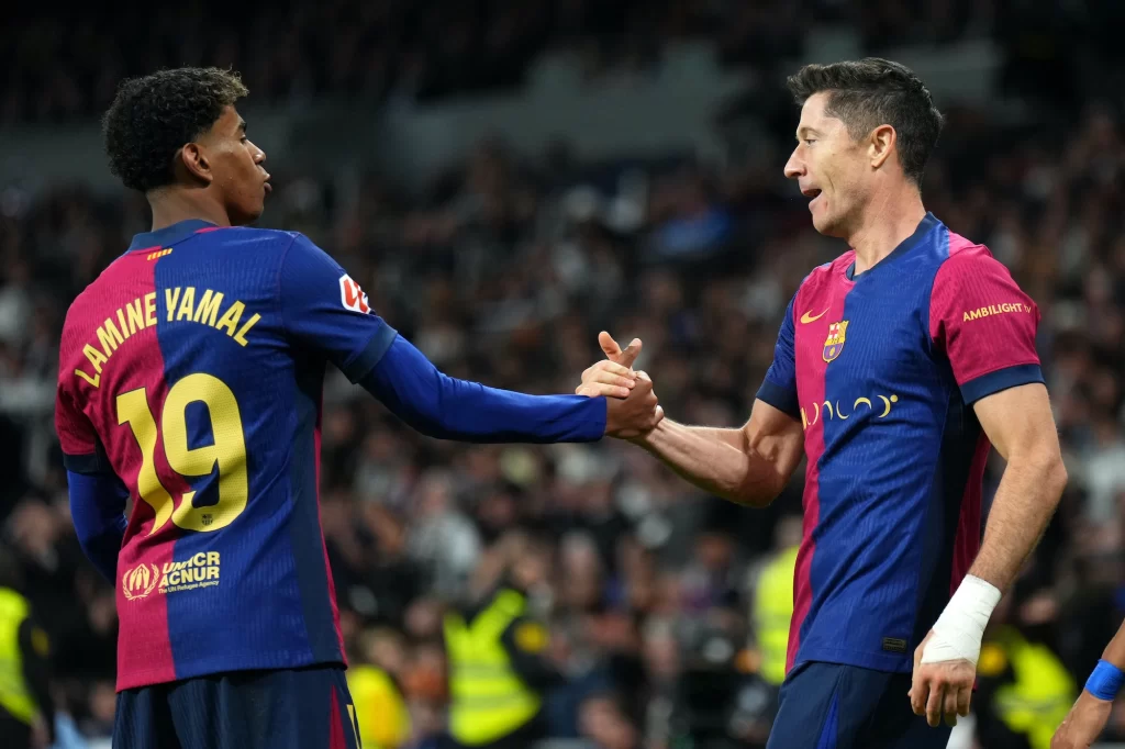 Robert Lewandowski del FC Barcelona celebra marcar el segundo gol de su equipo con su compañero Lamine Yamal durante el partido de LaLiga entre el Real Madrid CF y el FC Barcelona en el Estadio Santiago Bernabeu el 26 de octubre de 2024 en Madrid, España. (Foto de Ángel Martínez/Getty Images)